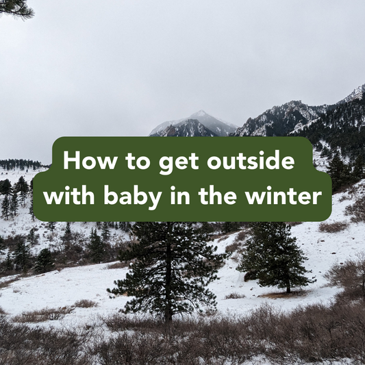 Text: How to get outside with baby in the winter. Background snow mountain and hillside with evergreen trees